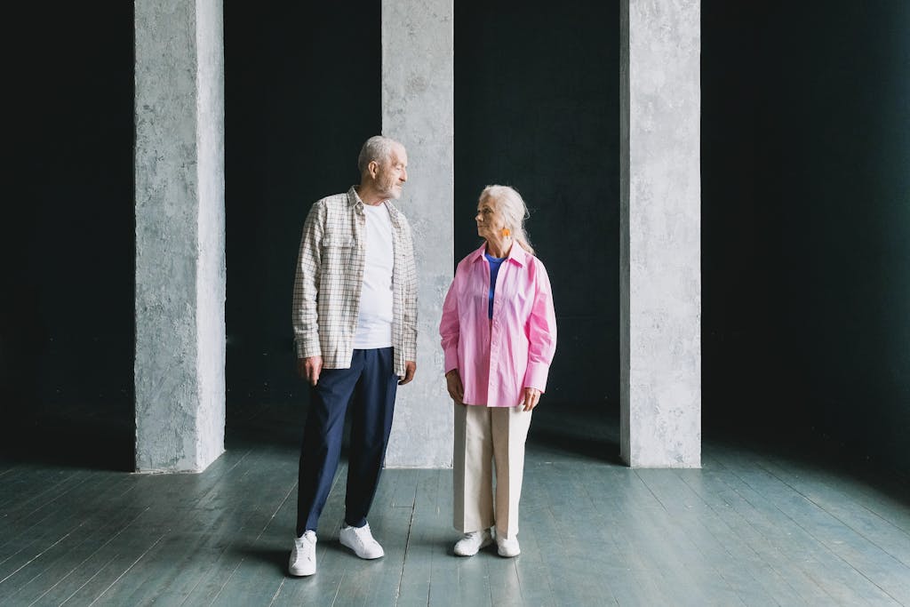 Senior couple standing in a modern, minimalist interior, sharing a moment.